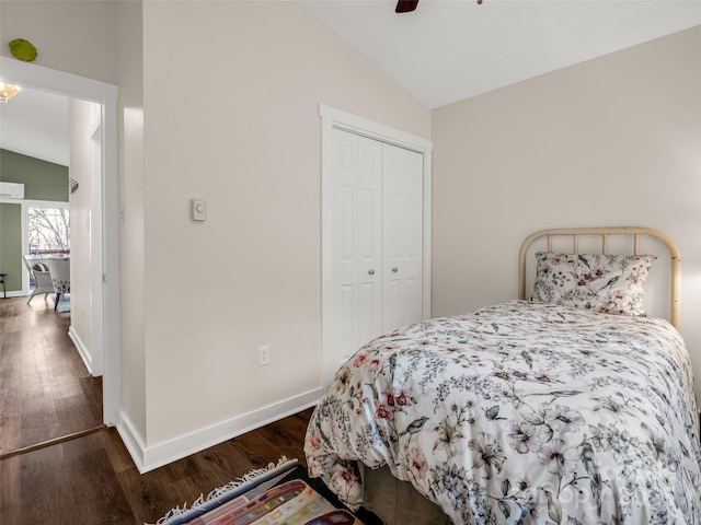 bedroom featuring lofted ceiling, baseboards, ceiling fan, a closet, and wood finished floors