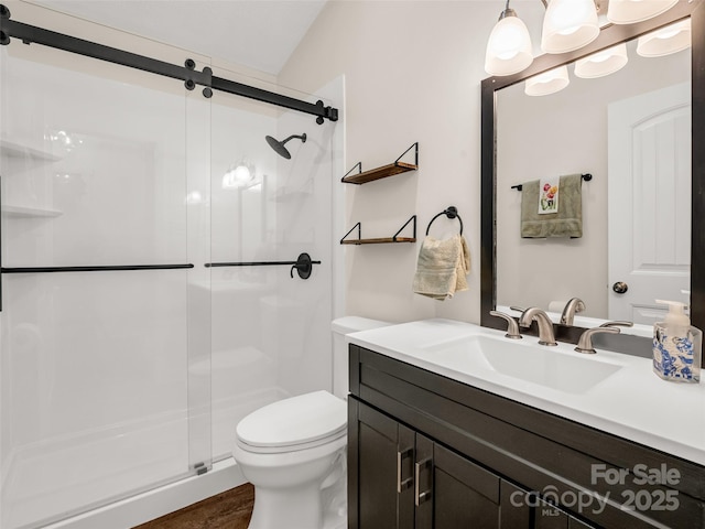 full bath featuring vanity, toilet, a shower stall, and wood finished floors