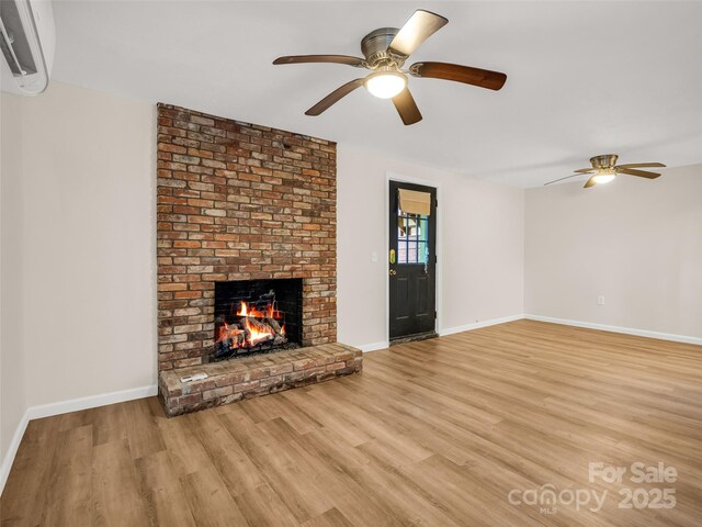 unfurnished living room featuring baseboards, light wood-style floors, a fireplace, and ceiling fan