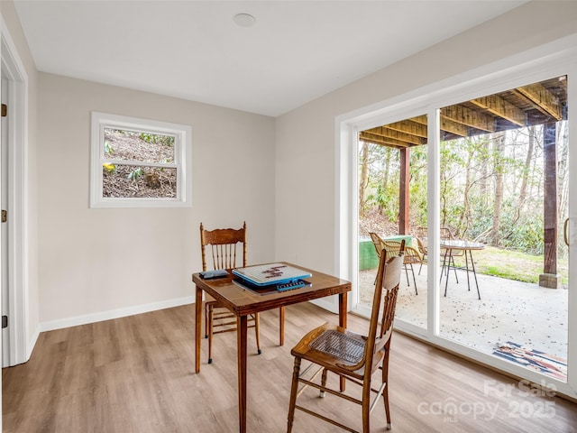 dining area with baseboards and light wood-style flooring