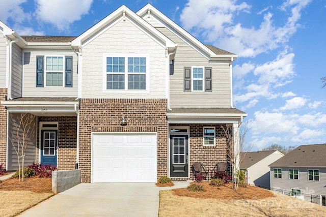 view of front of property featuring brick siding, concrete driveway, and a garage