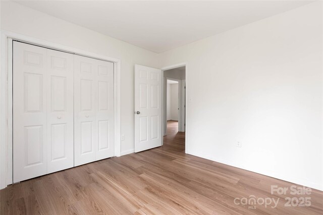 2694 W Lakeshore Dr, Landrum, SC 29356 - unfurnished bedroom featuring light wood-style floors, a closet, and baseboards