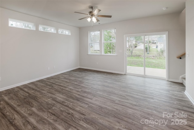 interior space featuring a ceiling fan, dark wood-style floors, baseboards, and stairway