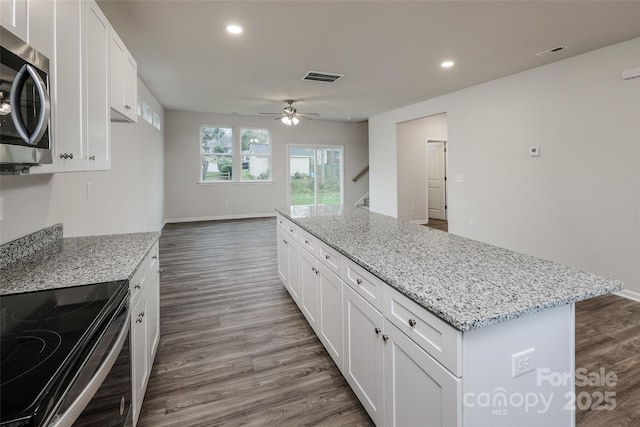 kitchen featuring stainless steel microwave, a ceiling fan, visible vents, and electric stove