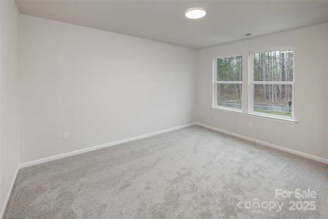 carpeted empty room with baseboards and visible vents