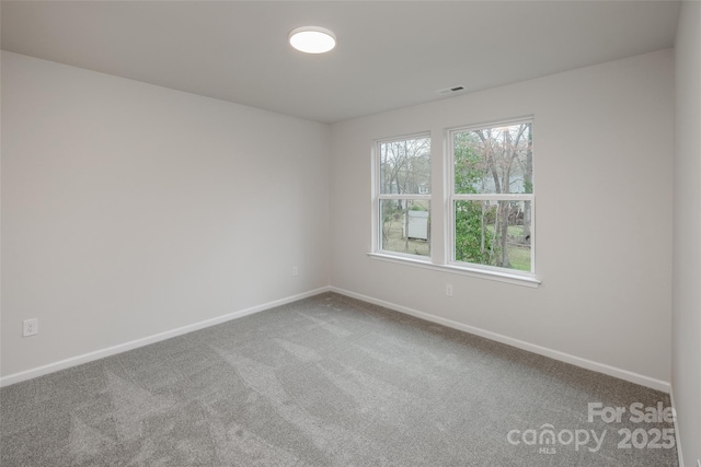 carpeted spare room featuring baseboards and visible vents