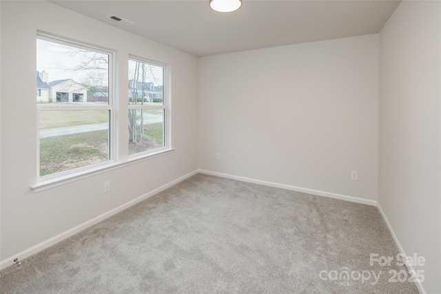 carpeted empty room with baseboards and visible vents