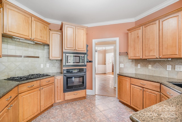 kitchen with oven, gas cooktop, stone countertops, stainless steel microwave, and ornamental molding