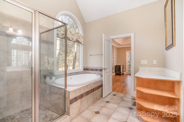 bathroom with a bath, tile patterned flooring, vaulted ceiling, a stall shower, and vanity