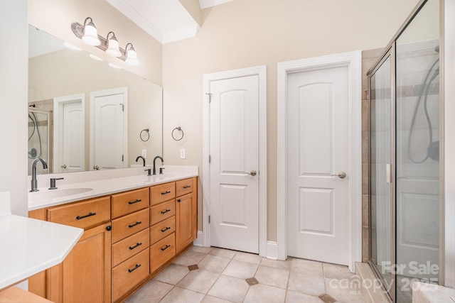 bathroom with a sink, tile patterned flooring, a stall shower, and double vanity