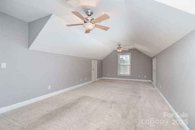 additional living space with light colored carpet, a ceiling fan, baseboards, and lofted ceiling