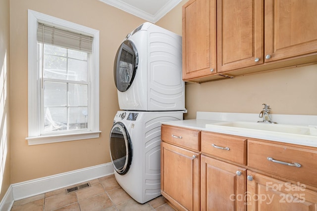 laundry room with visible vents, cabinet space, baseboards, ornamental molding, and stacked washer and clothes dryer