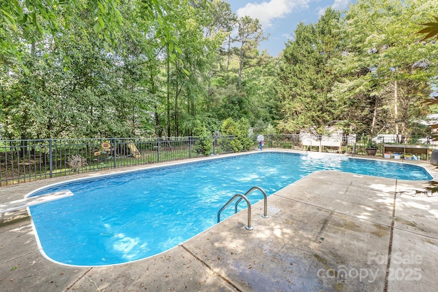 view of pool with a patio area, a fenced in pool, and fence