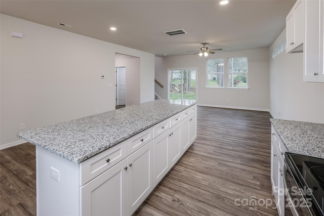 kitchen featuring dark wood-style floors, black range with electric stovetop, visible vents, and ceiling fan