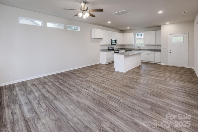 kitchen with white cabinets, stainless steel appliances, and open floor plan
