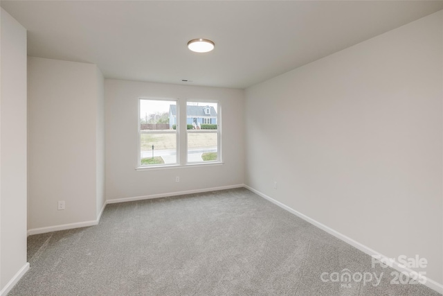 carpeted empty room with baseboards