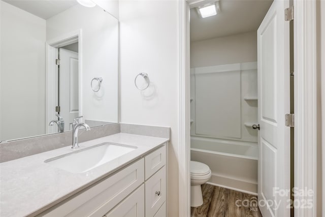 full bathroom with tub / shower combination, toilet, vanity, and wood finished floors