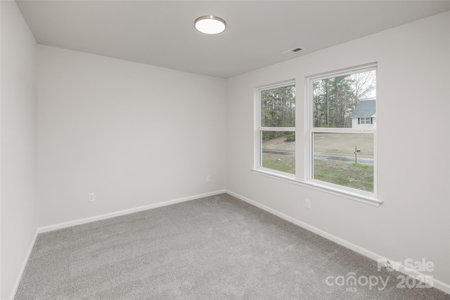 unfurnished room featuring baseboards, carpet flooring, and visible vents