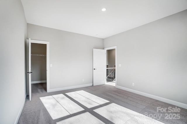 522 Fern Hill Rd Unit 17, Mooresville, NC 28117 - unfurnished bedroom featuring a walk in closet, baseboards, and carpet floors