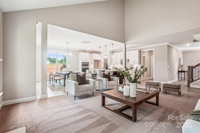 522 Fern Hill Rd Unit 17, Mooresville, NC 28117 - living area with stairs, light carpet, crown molding, high vaulted ceiling, and a chandelier