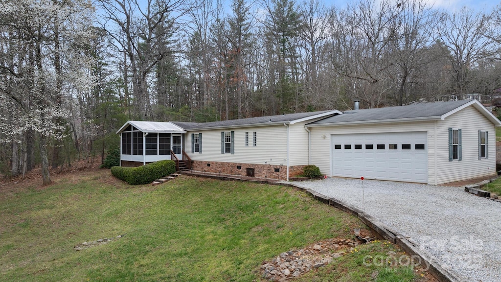 view of front of house featuring driveway, an attached garage, a front lawn, a sunroom, and crawl space