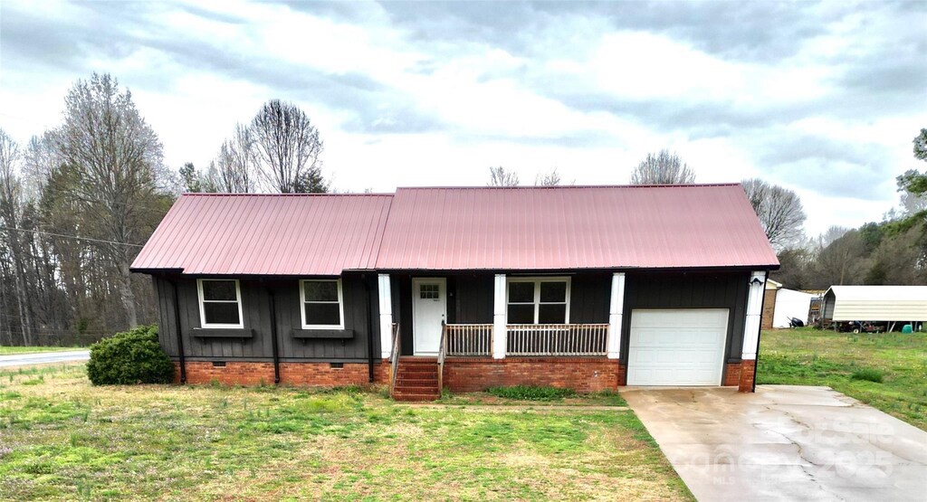 2180 Grace Church Rd, Salisbury, NC 28147 - view of front facade with a front yard, concrete driveway, an attached garage, crawl space, and a porch