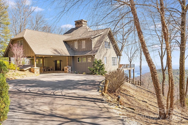 315 Jocassee Trl, Sapphire, NC 28774 - view of front facade featuring roof with shingles, board and batten siding, concrete driveway, and a chimney