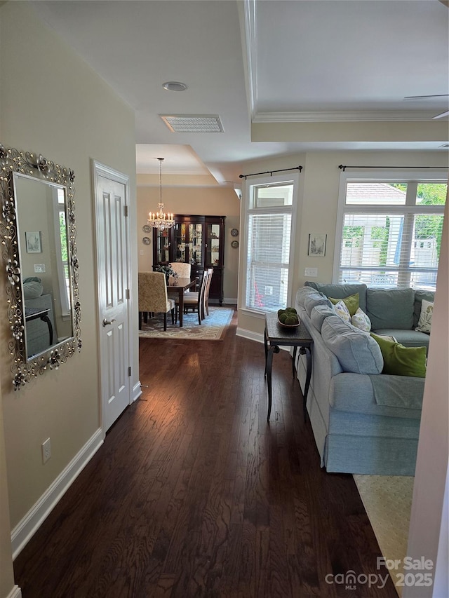 1112 Avalon Pl, Stallings, NC 28104 - living room with a chandelier, dark wood-style floors, a tray ceiling, crown molding, and baseboards
