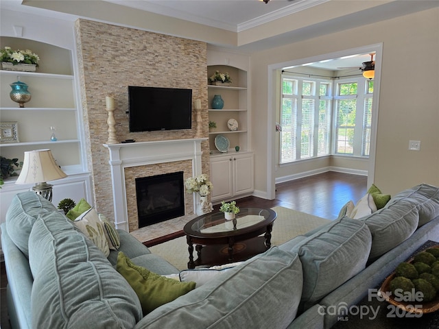1112 Avalon Pl, Stallings, NC 28104 - living area featuring built in features, wood finished floors, ornamental molding, a ceiling fan, and a stone fireplace