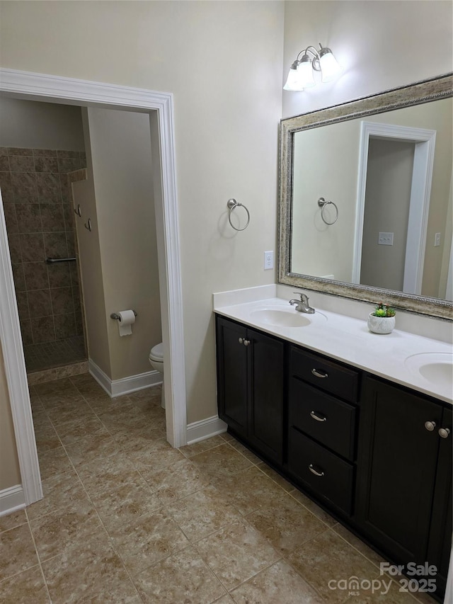 1112 Avalon Pl, Stallings, NC 28104 - bathroom featuring double vanity, toilet, a tile shower, and baseboards