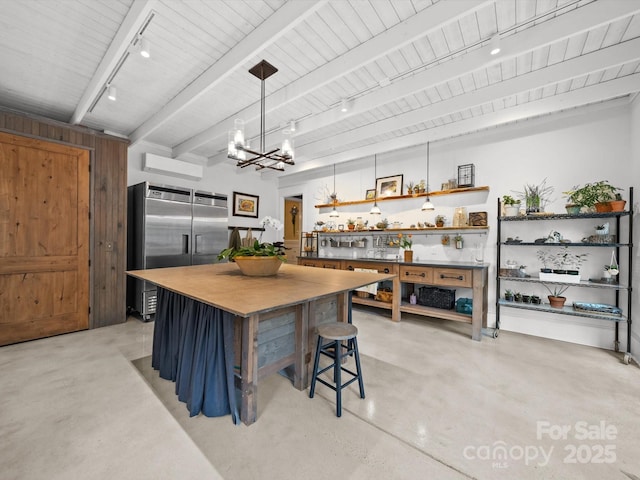 kitchen featuring beam ceiling, an inviting chandelier, concrete flooring, open shelves, and rail lighting