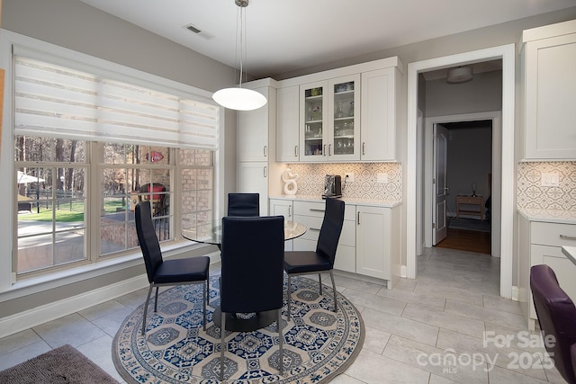 dining room featuring light tile patterned flooring, baseboards, and visible vents