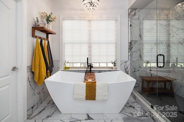bathroom with marble finish floor, a marble finish shower, a freestanding tub, a sink, and an inviting chandelier