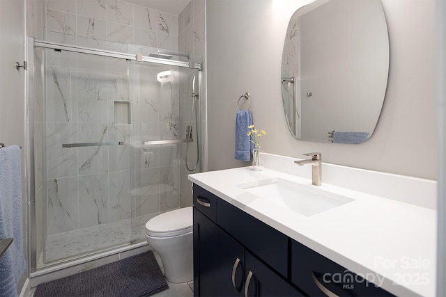 full bathroom with a marble finish shower, toilet, and vanity