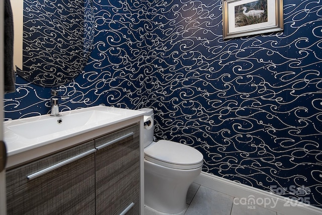 half bathroom with tile patterned floors, vanity, and toilet
