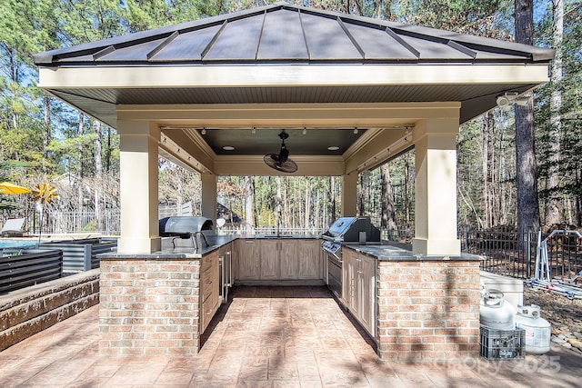 view of patio with grilling area, area for grilling, fence, and ceiling fan