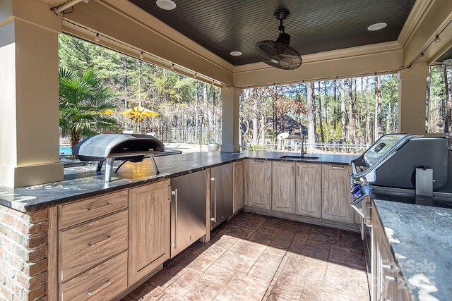 view of patio with a grill, fence, a sink, and a ceiling fan