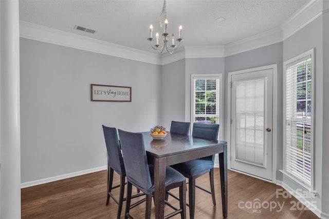1017 Chalk Hill Ln, Charlotte, NC 28214 - dining area featuring ornamental molding, a chandelier, plenty of natural light, wood finished floors, and a textured ceiling