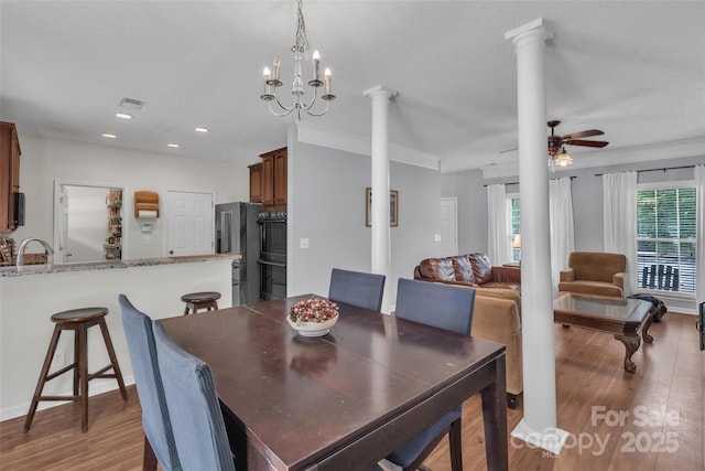 1017 Chalk Hill Ln, Charlotte, NC 28214 - dining space with decorative columns, light wood-type flooring, ceiling fan, recessed lighting, and a chandelier