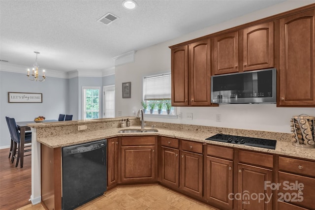 1017 Chalk Hill Ln, Charlotte, NC 28214 - kitchen with black appliances, a sink, a peninsula, light stone counters, and a chandelier