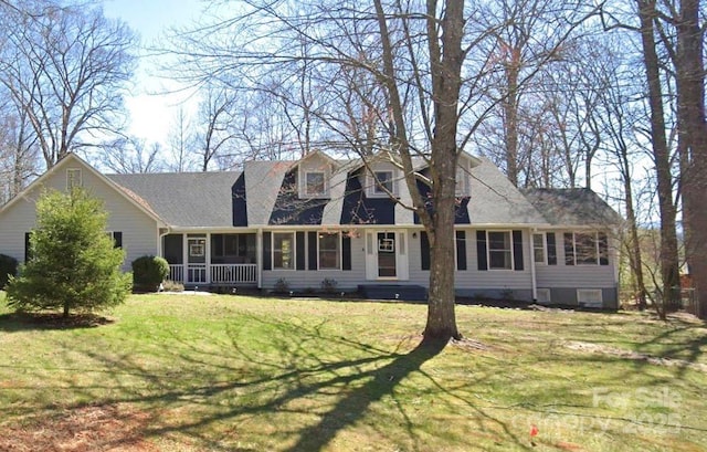 view of front of property with a shingled roof, a front yard, and a sunroom