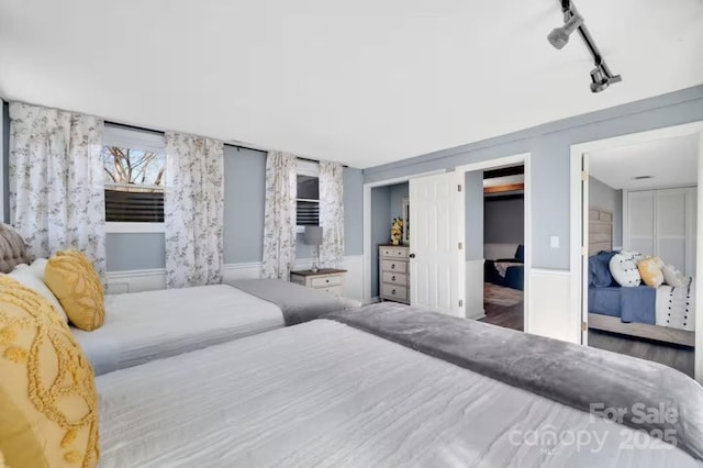 bedroom with wallpapered walls and track lighting