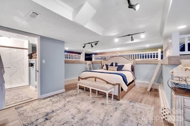 bedroom featuring wood finished floors, baseboards, and visible vents