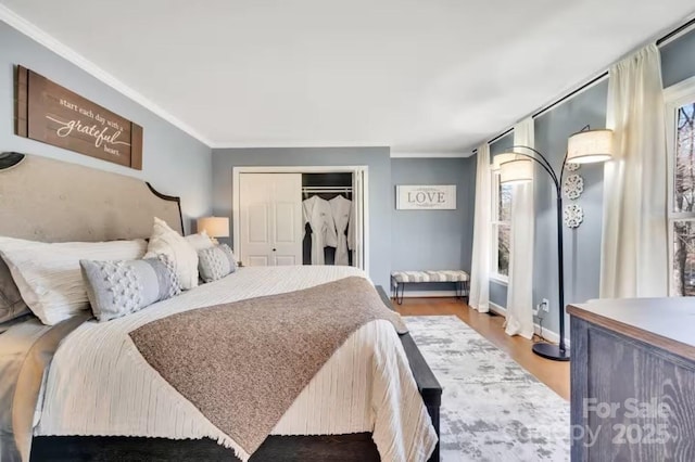 bedroom with a closet, wood finished floors, and ornamental molding
