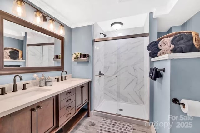 bathroom featuring a marble finish shower, double vanity, and a sink