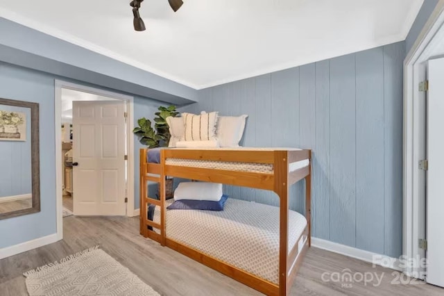 bedroom featuring a ceiling fan, baseboards, and wood finished floors