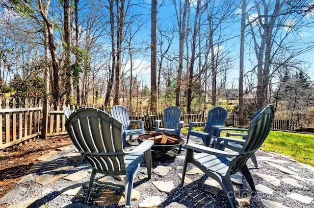 view of patio featuring an outdoor fire pit and fence