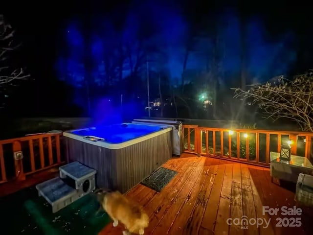 deck at twilight featuring a hot tub