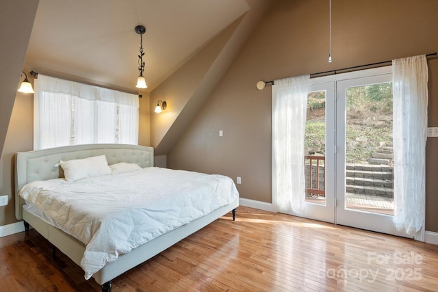 1506 Lynn Rd, Columbus, NC 28722 - bedroom with access to exterior, hardwood / wood-style flooring, multiple windows, and vaulted ceiling