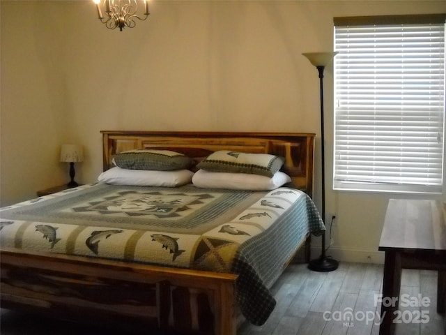 992 Hornet Dr, Whittier, NC 28789 - bedroom featuring baseboards, wood finished floors, and an inviting chandelier